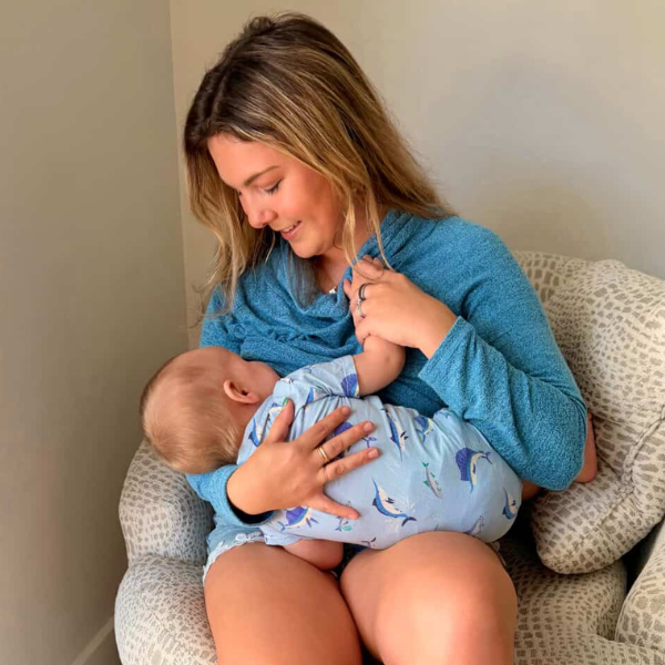 Mom breastfeeding newborn showing proper latch and calm nursing hold as part of a sustainable breastfeeding support system at home