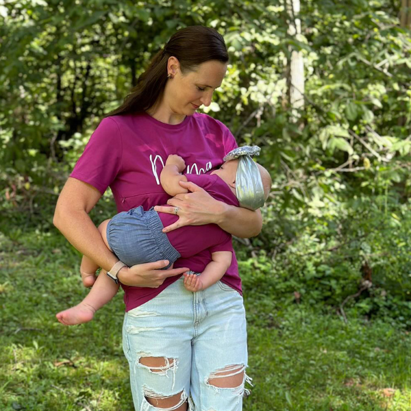 Mom nursing her baby in pink breastfeeding shirt