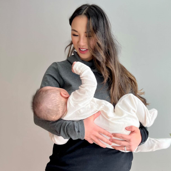 Mom nursing her baby using a breastfeeding sweatshirt with hidden access for nursing or pumping on the go