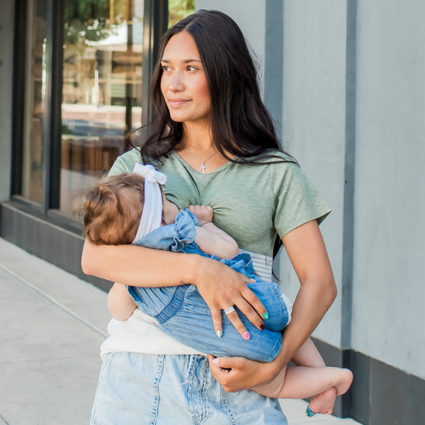 Mom nursing her baby wearing a green shirt with hidden breastfeeding access