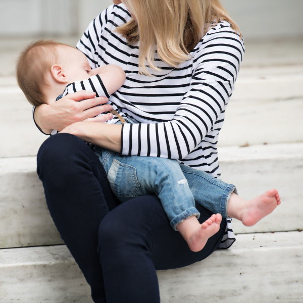 mom nursing her baby wearing a striped shirt with a hidden zipper for breastfeeding access
