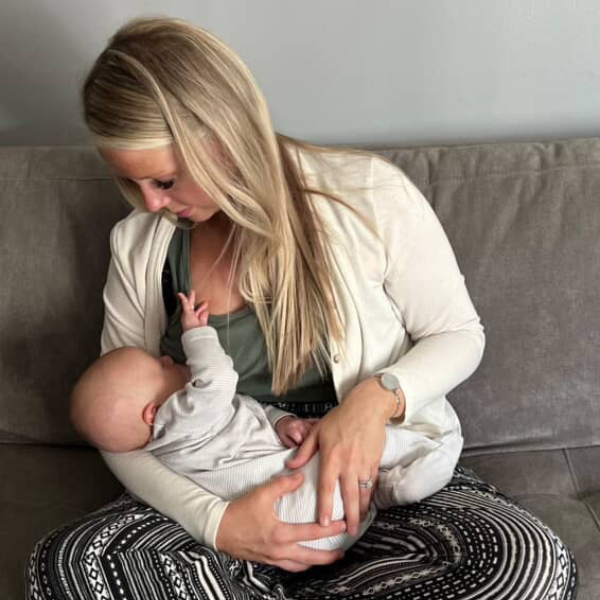 Mom nursing her baby in sage tank top