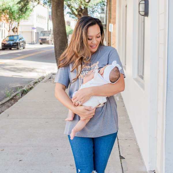 Mom feeding her baby using a nursing shirt with hidden breastfeeding access