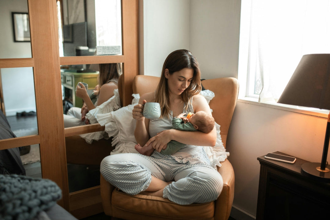 woman holding baby and mug