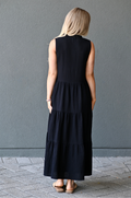 Back view of a woman wearing a black cotton nursing dress with hidden zipper access for breastfeeding. 