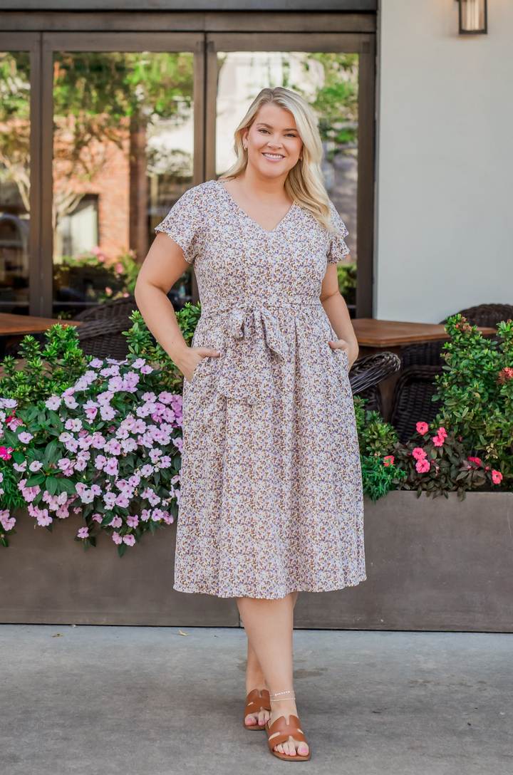 The Nursing Queen belted midi breastfeeding dress in beige floral print is shown from the front with a flattering waist-defining silhouette.