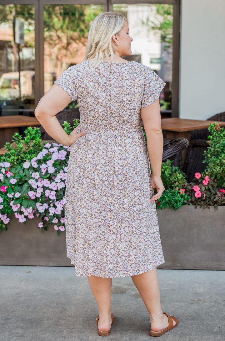 A detail shot of the breezy floral pattern and fabric texture on the beige midi breastfeeding dress emphasizes quality and comfort.
