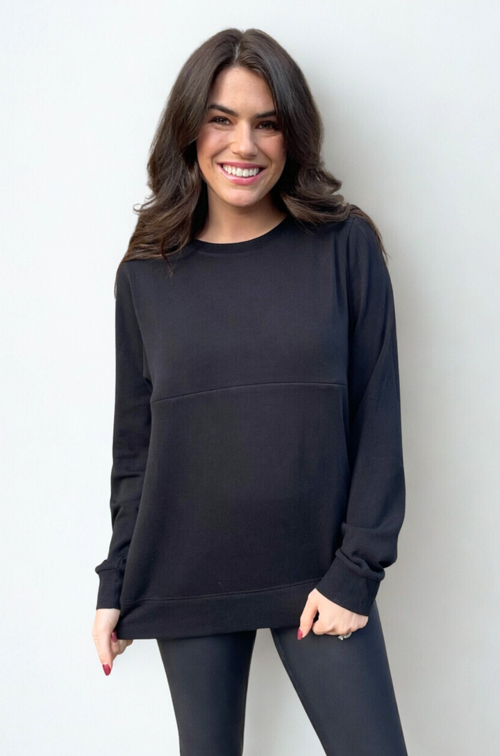 A model wearing a black crewneck breastfeeding sweatshirt with hidden zipper access for everyday comfort.