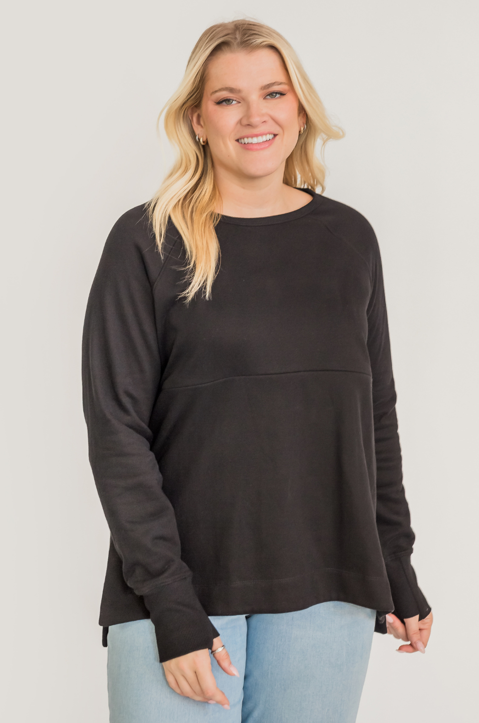 Woman wearing a breastfeeding nursing tunic with hidden access for pumping and nursing