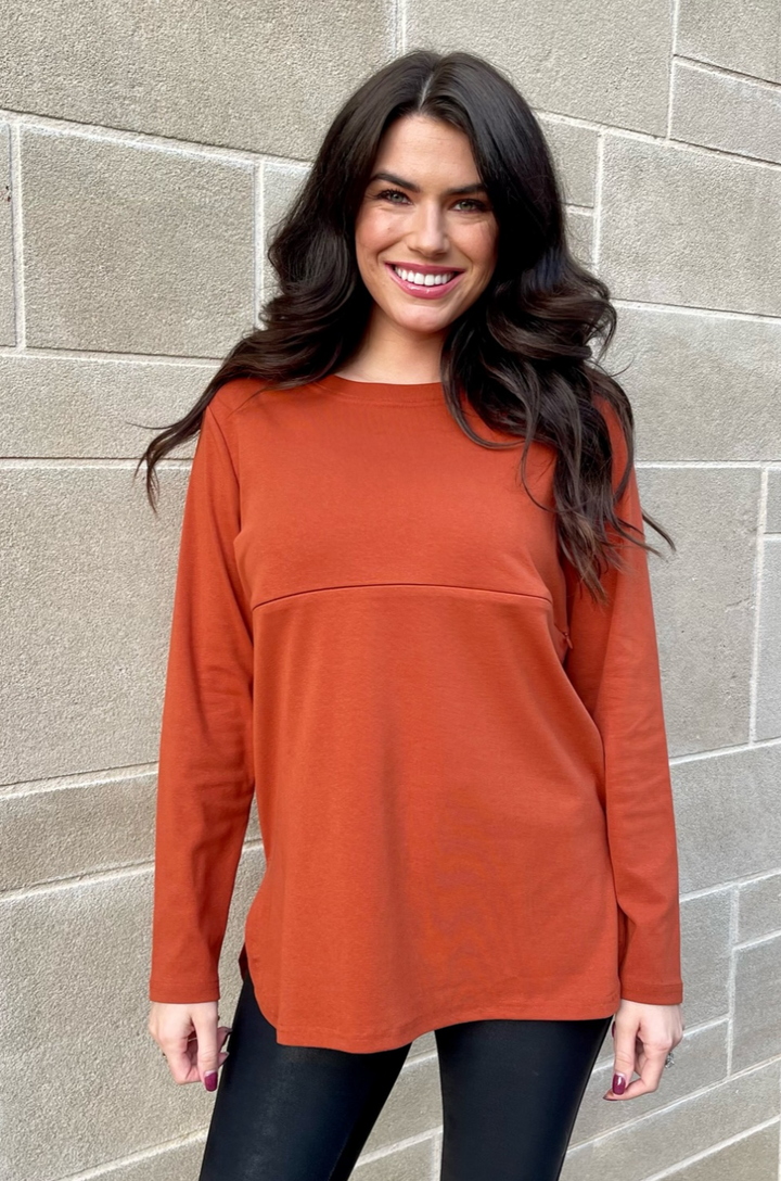Front view of rust long sleeve breastfeeding tunic top with relaxed fit and concealed zipper nursing access