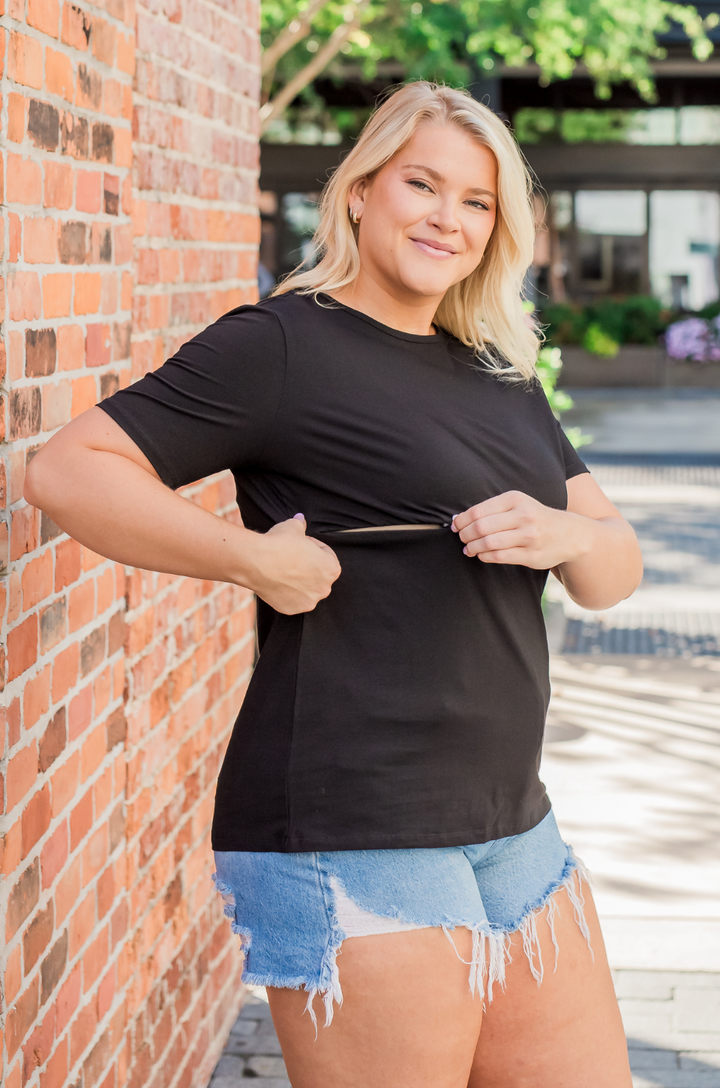 Close-up of hidden zipper nursing access on black cotton breastfeeding short partially open for feeding a baby. 