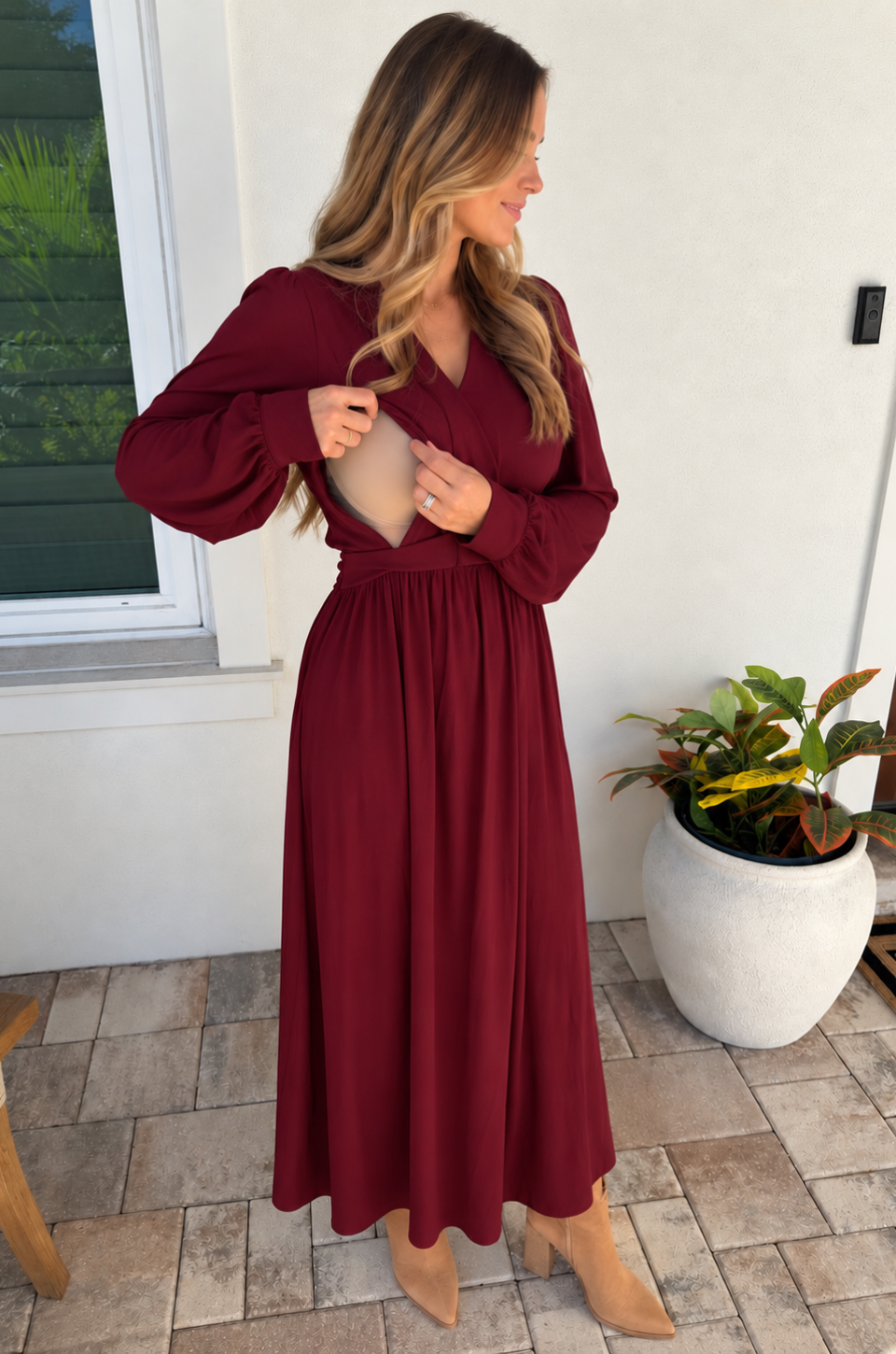 Mom wearing a deep red nursing dress with hidden access for breastfeeding on the go.