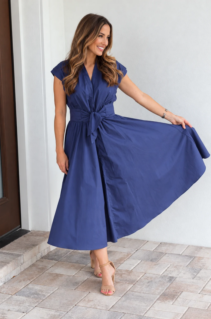 view of mom showing how flowy a cotton nursing dress is while standing on the front porch