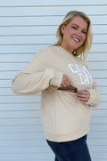 Woman showing nursing access in a game day sweatshirt 