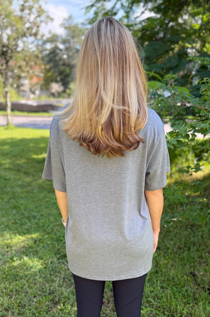 A back view shows a mom wearing the Nashville nursing graphic gray t-shirt with leggings, highlighting a relaxed fit and full coverage.