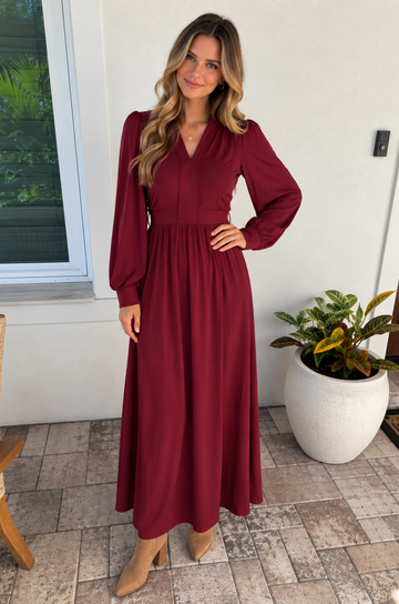 Mom wearing a deep red nursing dress with hidden breastfeeding access standing on a front porch for fall