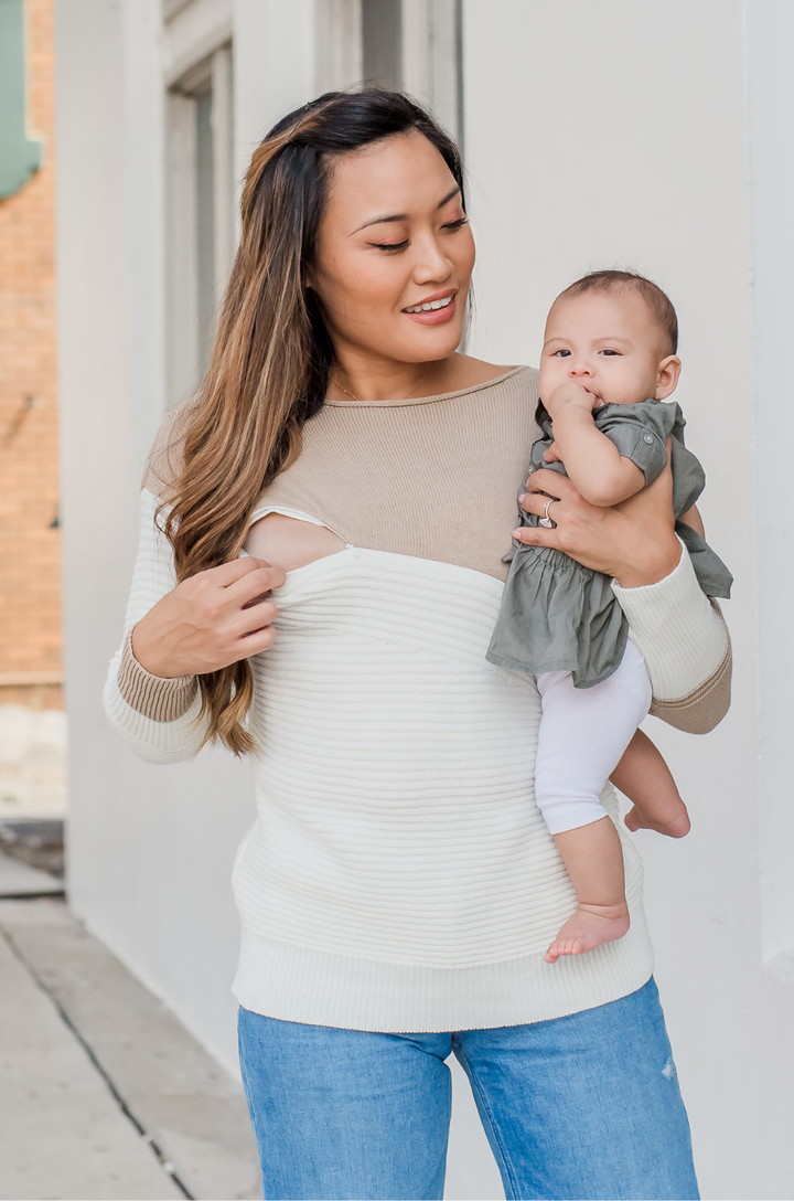 Close-up of hidden zipper on tan and cream ribbed knit breastfeeding sweater, partially opened to show nursing access.