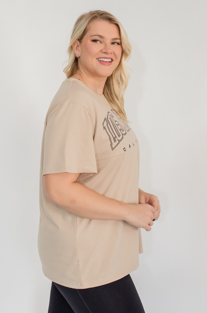 A side view shows a mom wearing the Los Angeles California breastfeeding graphic tan t-shirt, emphasizing its soft fabric and easy movement.