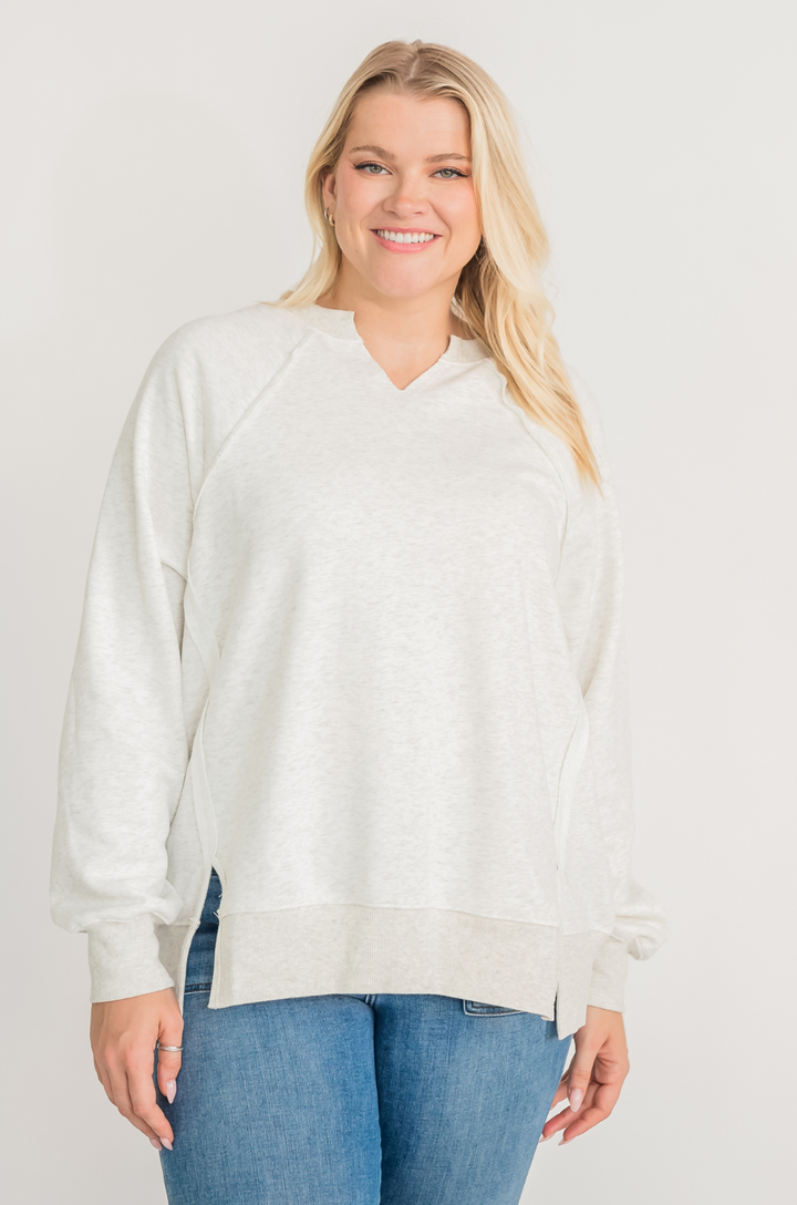 Front view of light gray super oversized breastfeeding sweatshirt worn with jeans, showing relaxed fit and hidden zipper access.