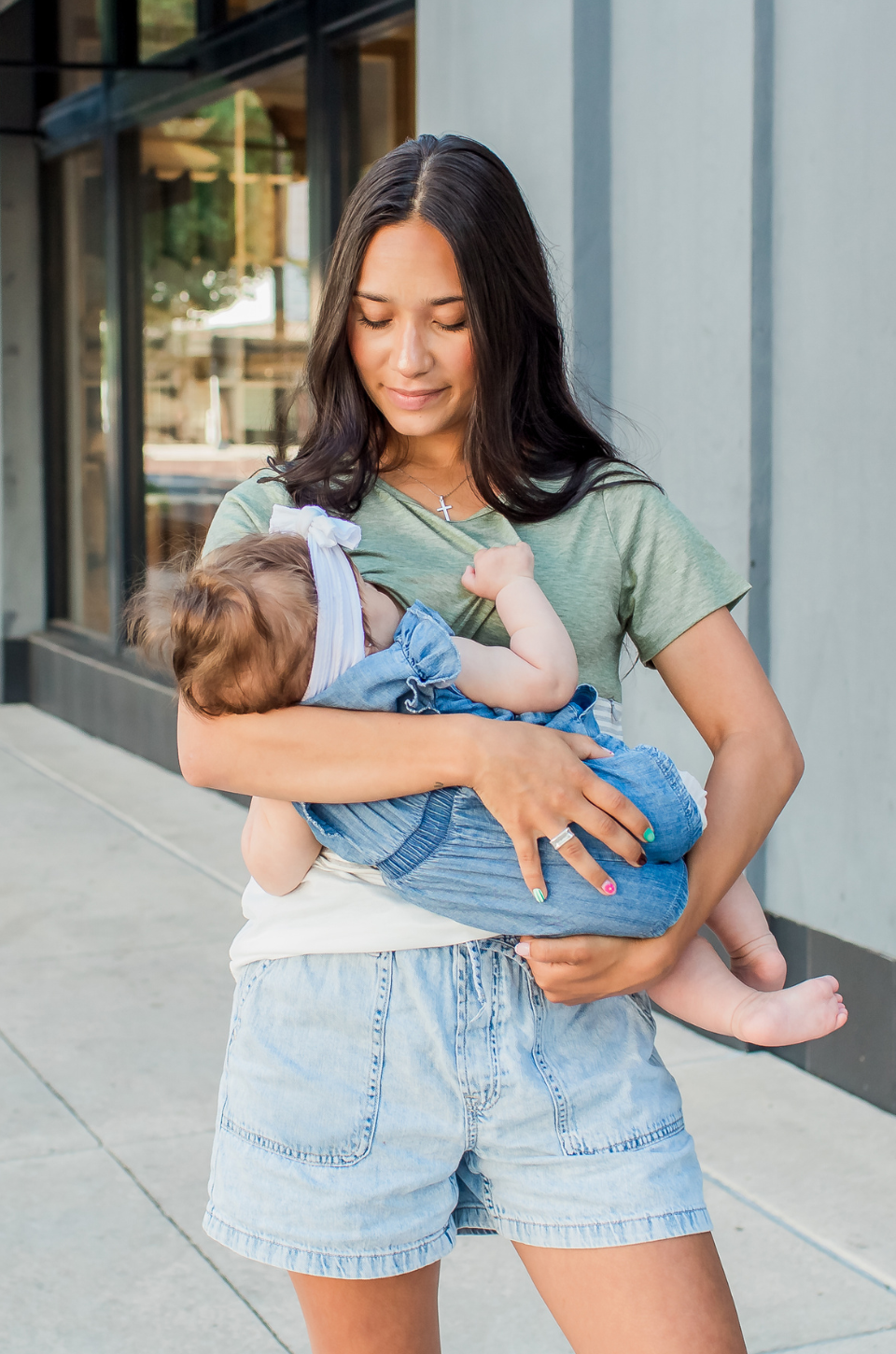 Mom nursing her baby wearing a breastfeeding shirt with hidden zipper access
