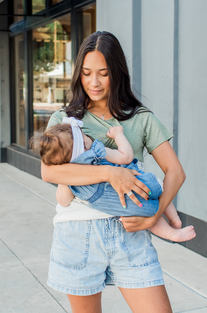 Mom nursing her baby wearing a breastfeeding shirt with hidden zipper access