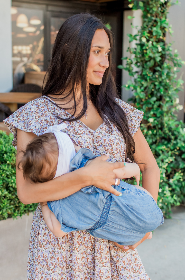 Mom nursing her baby using a spring and summer dress with hidden breastfeeding access built into the design. 