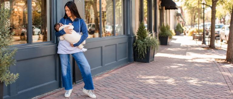 Mom wearing a blue nursing hoodie breastfeeding her baby
