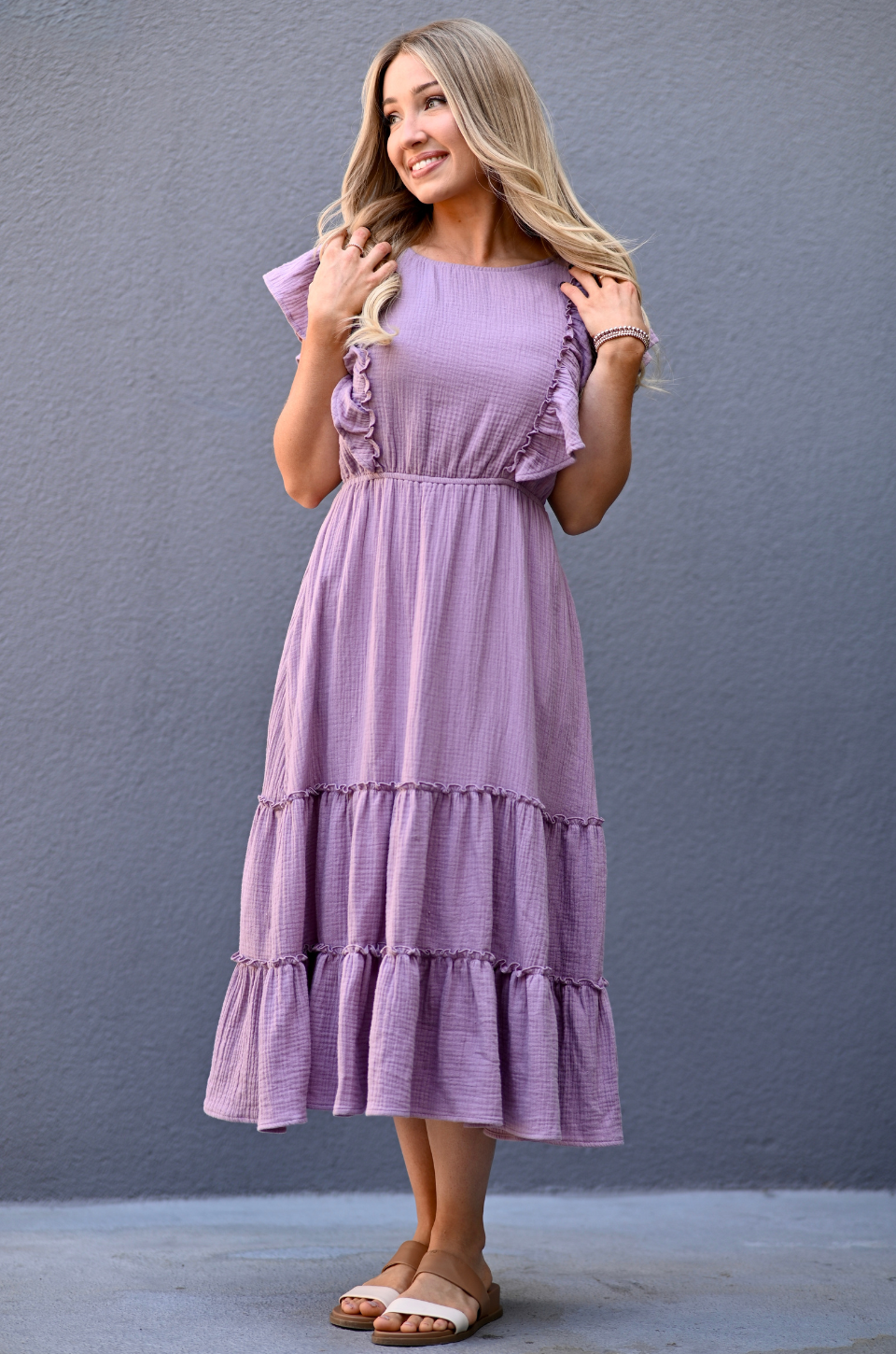 Woman wearing a lavender gauze ruffle midi nursing dress with hidden zipper breastfeeding access and pockets by Nursing Queen.