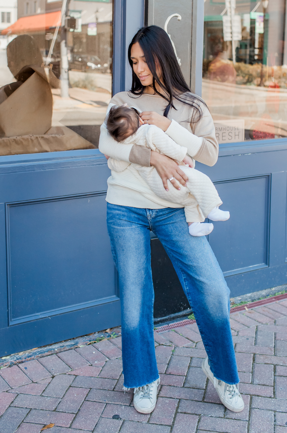Mom nursing her baby while wearing a breastfeeding knit sweater with hidden access. 