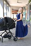 Woman wearing a 100% cotton nursing dress pushing a stroller. 