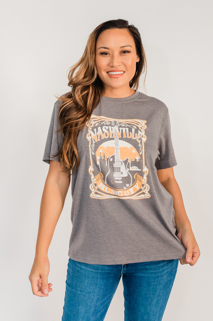 The Nashville nursing graphic gray t-shirt is shown from the front on a mom, highlighting the bold graphic and relaxed fit.