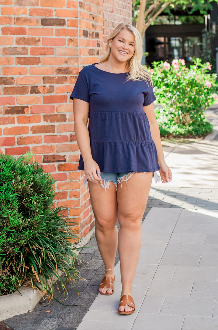 A mom wearing this cotton breastfeeding top styled with shorts.