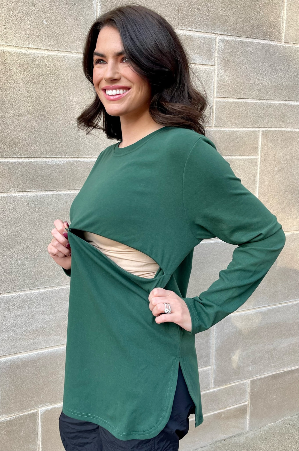 Close-up of hidden breastfeeding access on dark green long sleeve nursing tunic, partially opened