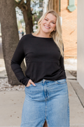 Woman wearing black nursing shirt and jean skirt