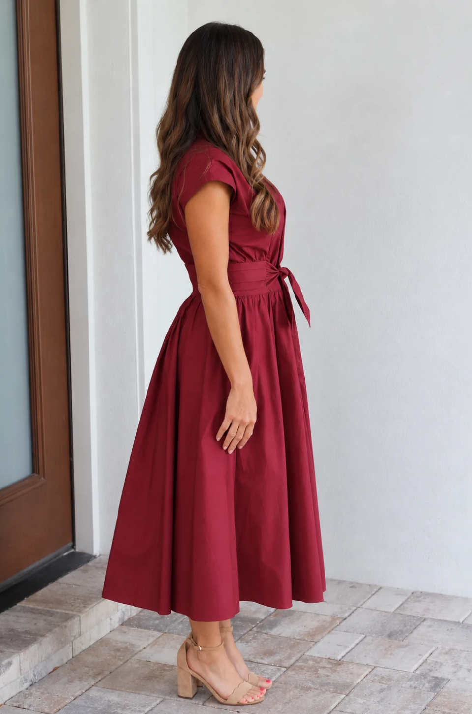Side view of a mom wearing a dark red breastfeeding dress for the fall and winter