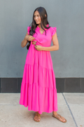 Mom wearing bright pink dress for breastfeeding showing how the hidden nursing access works