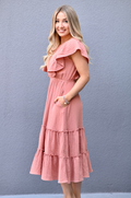 Side view of mom wearing a terracotta gauze midi nursing dress with tiered ruffle skirt and flattering silhouette suitable for postpartum wear.