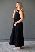 Side view of a woman wearing a black cotton nursing dress with hidden breastfeeding access