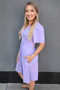 Short sleeve lilac breastfeeding dress by Nursing Queen featuring hidden nursing access, stretchy fabric, and flattering everyday silhouette