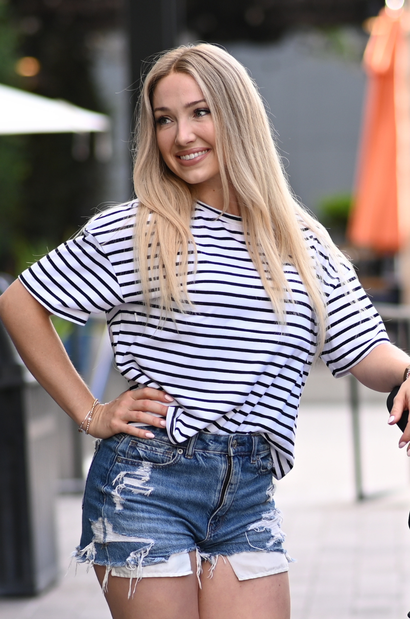Woman wearing a striped black and white nursing top with hidden breastfeeding access for nursing or pumping on the go in the summer. 
