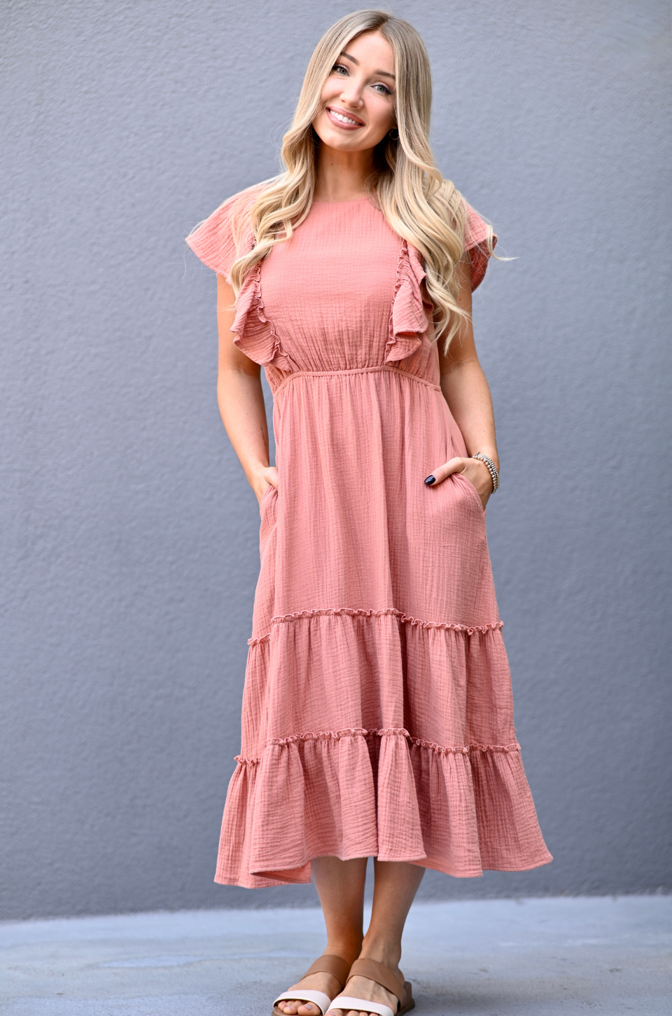 Woman wearing a terracotta gauze ruffle midi nursing dress with hidden zipper breastfeeding access, pockets, and flowy postpartum-friendly fit by Nursing Queen.