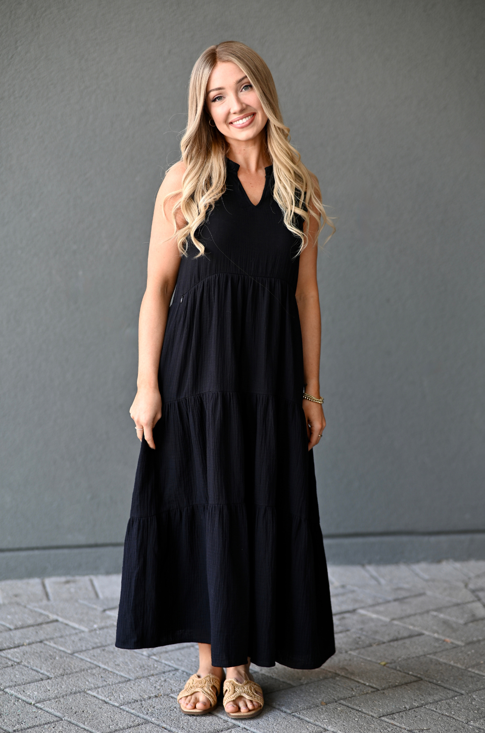 Woman wearing a black, cotton sleeveless nursing dress with hidden access for breastfeeding. 
