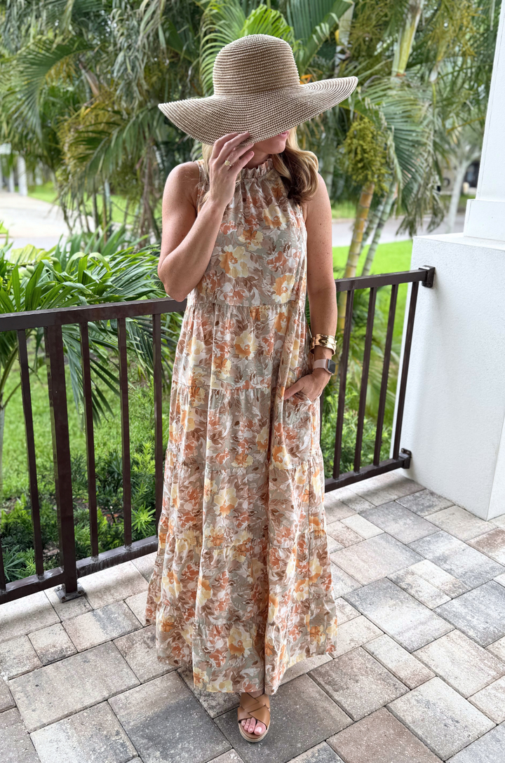 A mom wearing a Nursing Queen tie-back nursing dress in the floral sunset print shows a flattering silhouette and comfortable fit perfect for everyday wear.