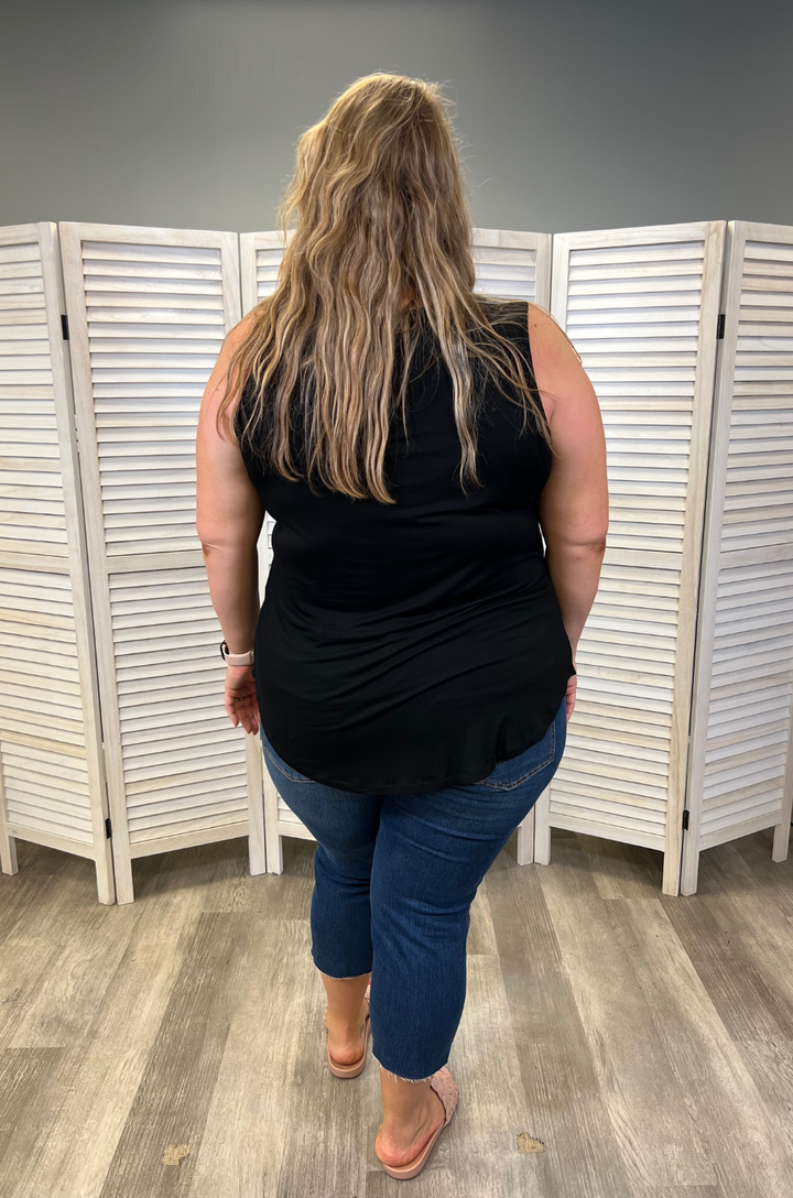 Back view of plus-size breastfeeding mom wearing the black swing nursing tank top styled with jeans.