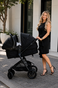 a woman with a stroller wearing a black formal breastfeeding dress