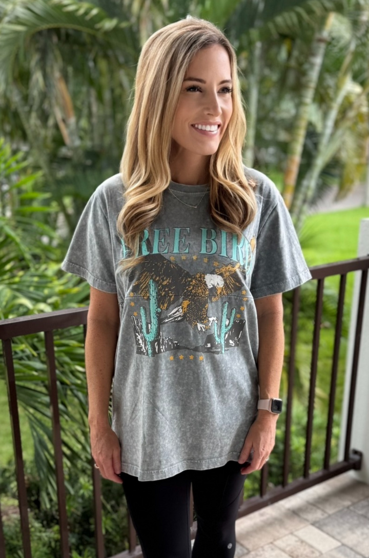 A mom wears the Free Bird graphic stonewash gray breastfeeding tee paired with leggings for a comfortable, everyday outfit.

