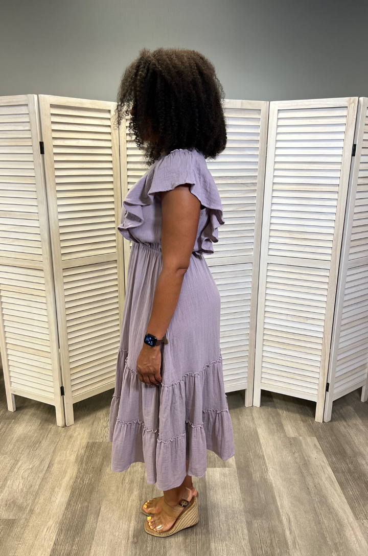 A side view shows a mom wearing the lavender gauze ruffle midi breastfeeding dress, highlighting its airy fabric and comfortable, flowy fit.