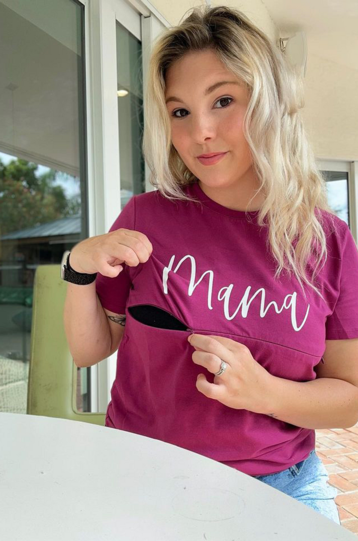 Close-up of cursive “mama” text on nursing tee with the zipper breastfeeding access open. 