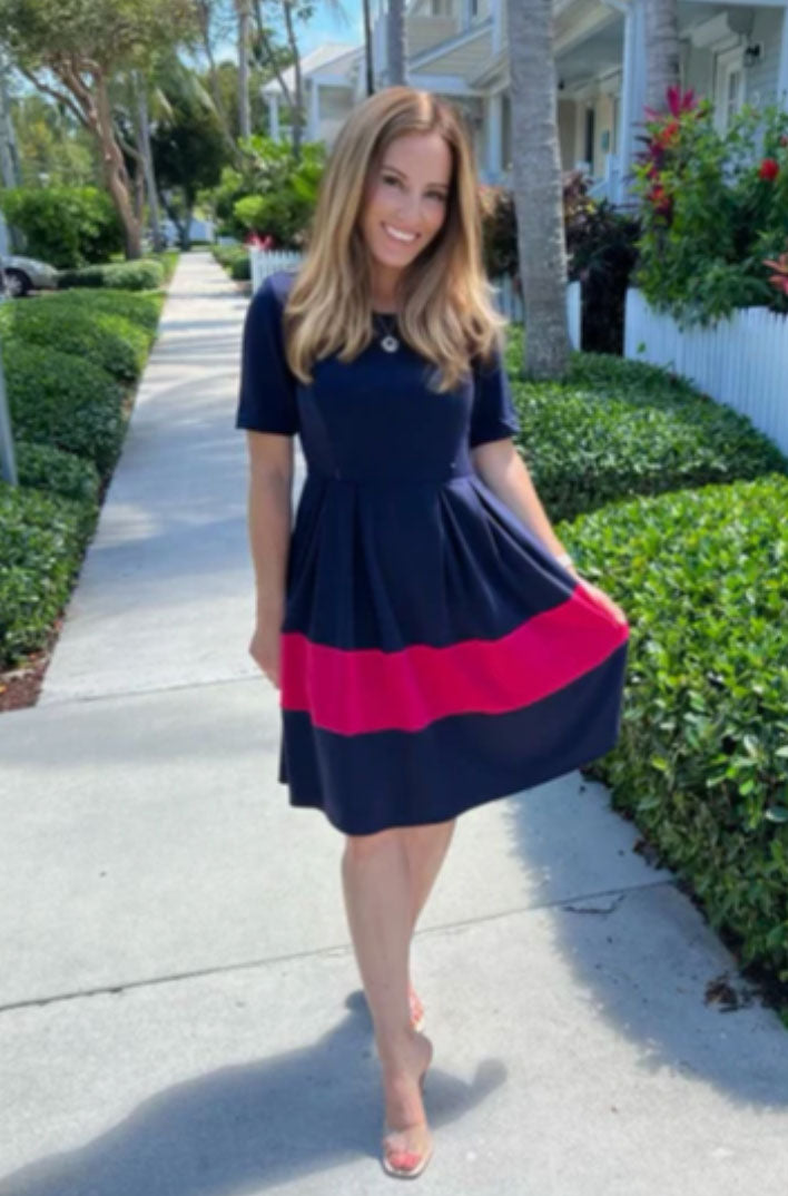 model wearing a navy and pink nursing dress