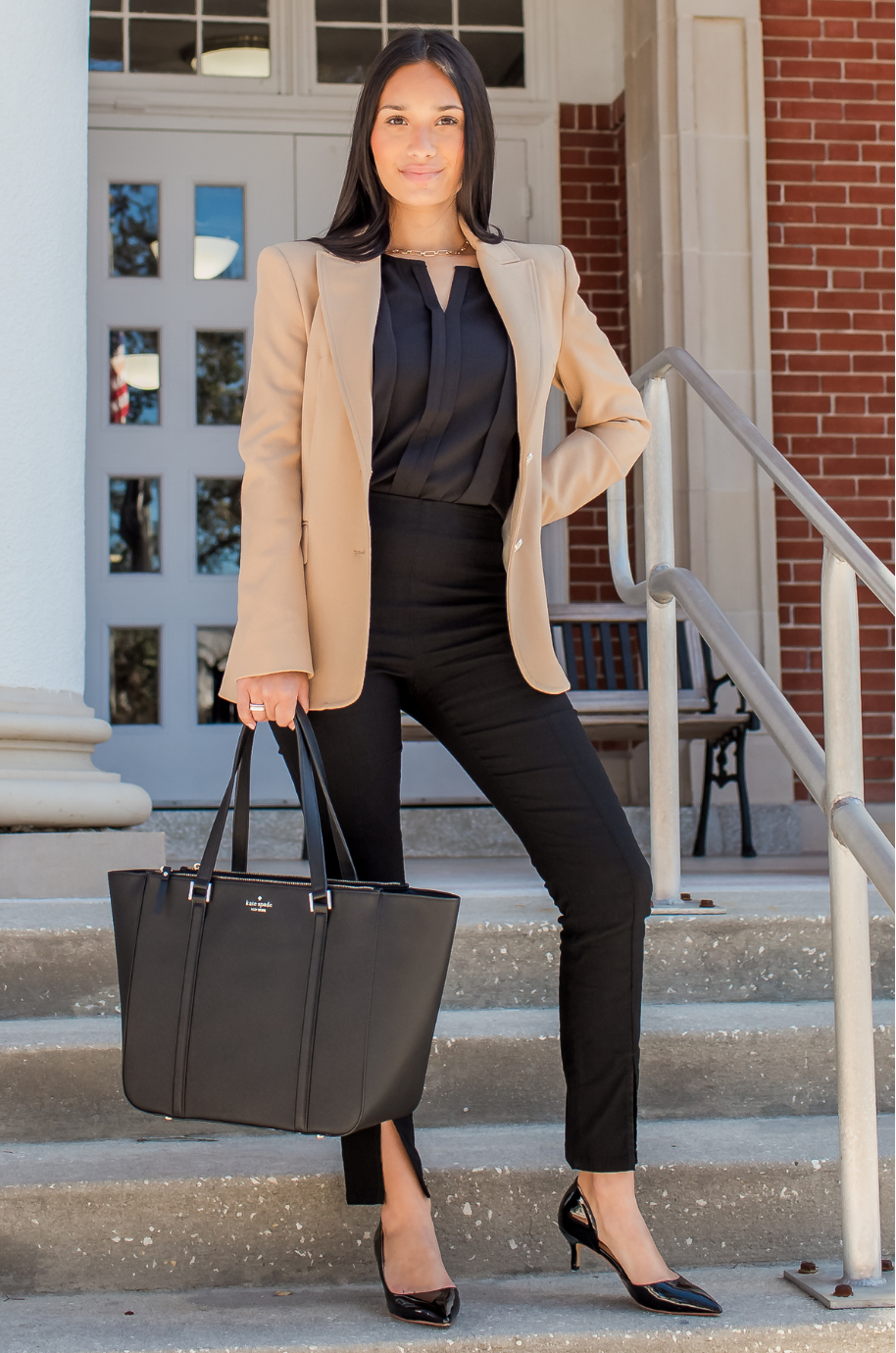 Mom in professional breastfeeding clothes holding a black tote bag on steps outside a building